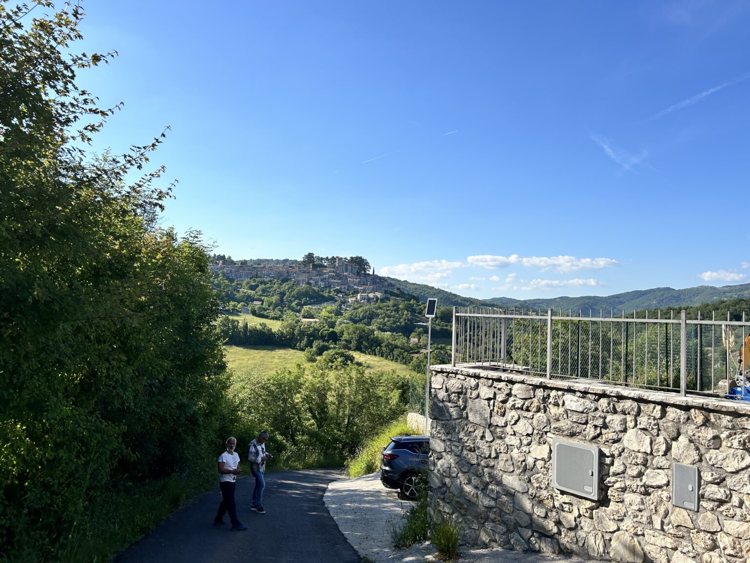 Lampadaire solaire UP1 discret, offrant un éclairage performant à un croisement de route près d'une habitation, avec vue sur le paysage vallonné d'Orvinio.